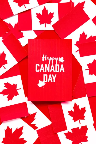 Card with text HAPPY CANADA DAY and flags on red background