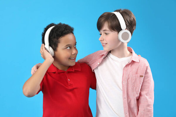 Little boys in headphones on blue background. Children's Day celebration