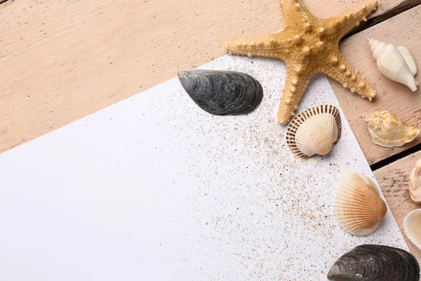 米色木制背景上有沙子 贝壳和海星的空白纸 — 图库照片
