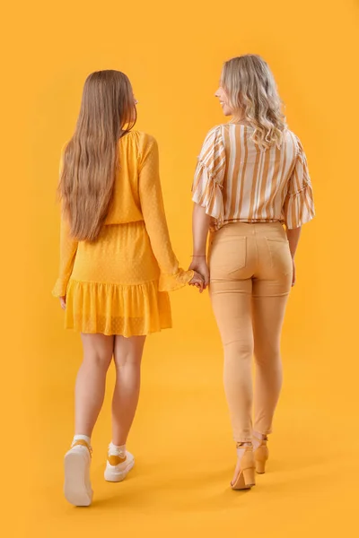 Young Sisters Holding Hands Yellow Background Back View — Stock Photo, Image