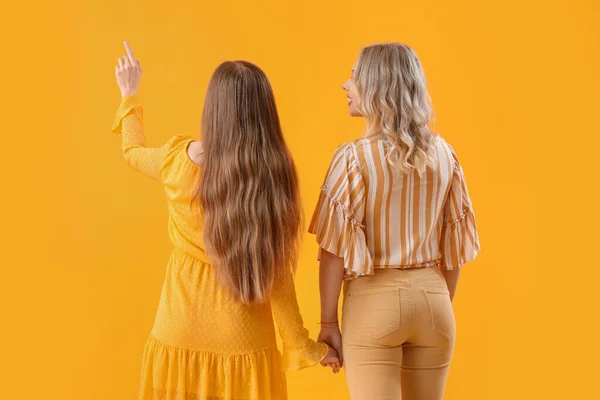 Młode Siostry Trzymające Się Ręce Żółtym Tle Widok Tyłu — Zdjęcie stockowe