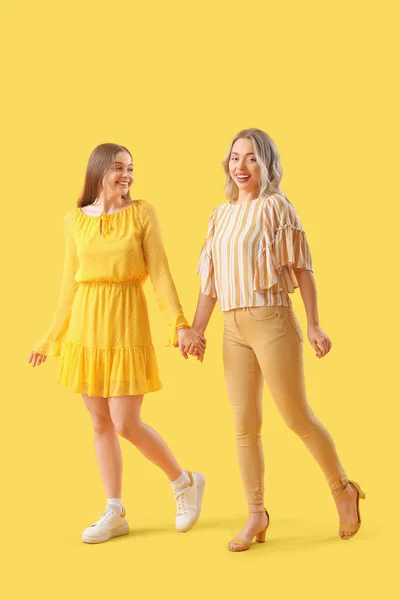 Young Sisters Holding Hands Yellow Background — Stock Photo, Image