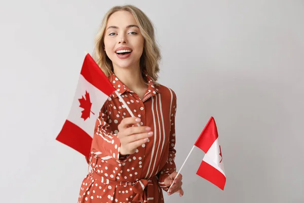 浅色背景的拿着加拿大国旗的年轻女子 — 图库照片