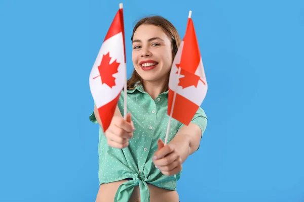 身穿蓝色背景加拿大国旗的年轻女子 — 图库照片