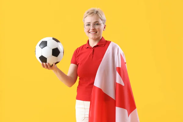 拿着加拿大国旗和黄底足球的年轻女子 — 图库照片