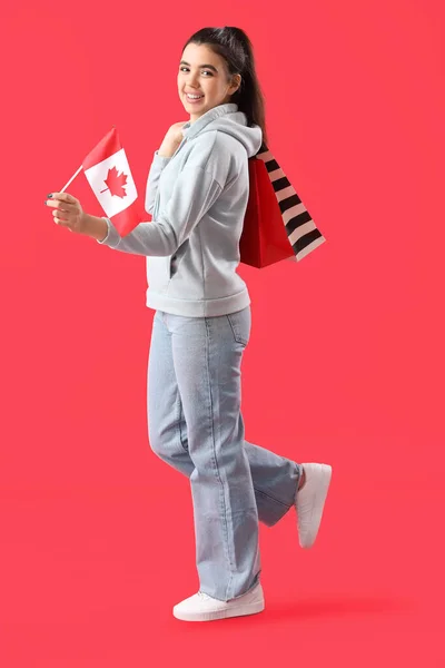 Kanada Bayrağı Kırmızı Arka Planda Alışveriş Torbaları Olan Genç Bir — Stok fotoğraf