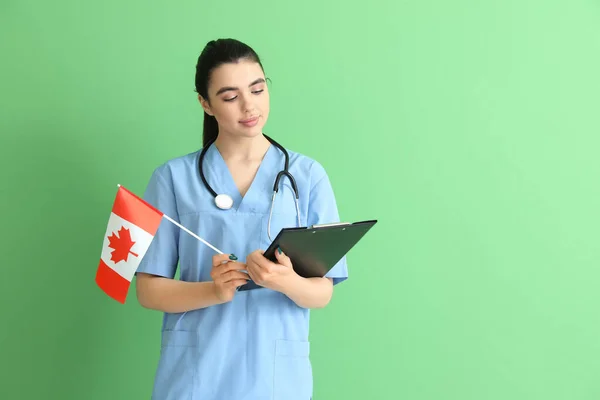 Médica Feminina Com Bandeira Canadá Área Transferência Fundo Verde — Fotografia de Stock
