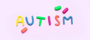Leylak arkaplanındaki plastikten yapılmış kelime AUTISM