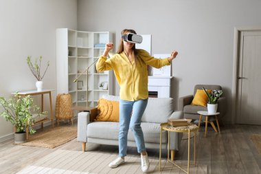 Pretty young woman in VR glasses at home