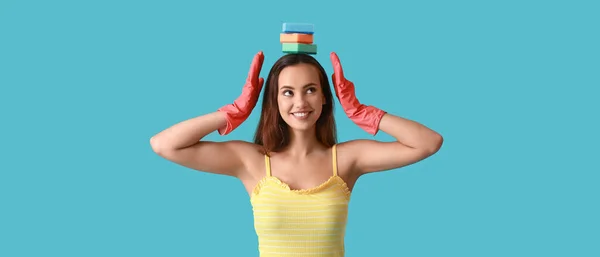 快乐的年轻女人 戴着橡胶手套 蓝色背景的清洁海绵 — 图库照片
