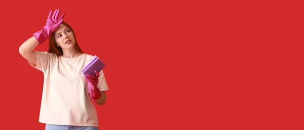 Müde Junge Frau Mit Gummihandschuhen Und Putzschwamm Auf Rotem Hintergrund — Stockfoto