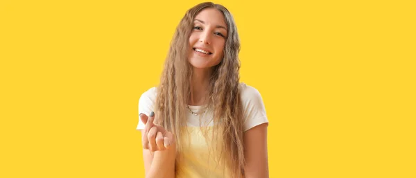 Szczęśliwa Młoda Kobieta Robi Kształt Serca Palcami Żółtym Tle — Zdjęcie stockowe