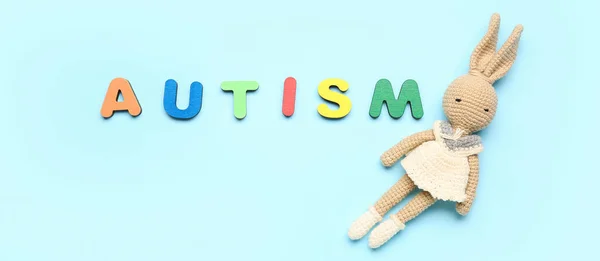 stock image Word AUTISM and toy on light blue background