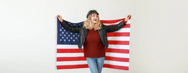 stock image Happy young woman with USA flag on light background