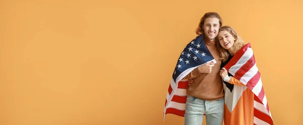 Pareja Joven Con Bandera Sobre Fondo Naranja Con Espacio Para —  Fotos de Stock