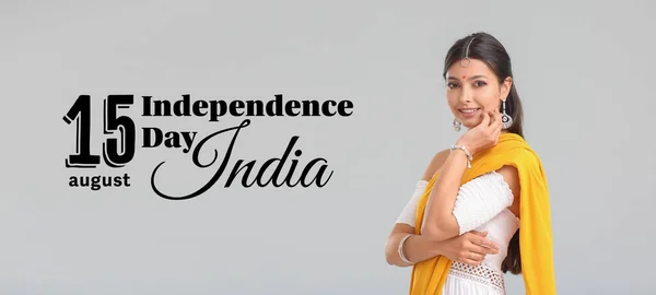 Beautiful woman in sari and text AUGUST 15, INDIA INDEPENDENCE DAY on grey background