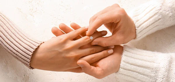 Man Sätta Förlovningsring Kvinnans Finger Mot Ljus Bakgrund — Stockfoto