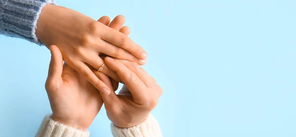 Hombre Poniendo Anillo Compromiso Dedo Mujer Sobre Fondo Azul Primer —  Fotos de Stock