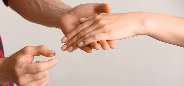 Мужчина Надевает Обручальное Кольцо Палец Женщины Светлом Фоне — стоковое фото