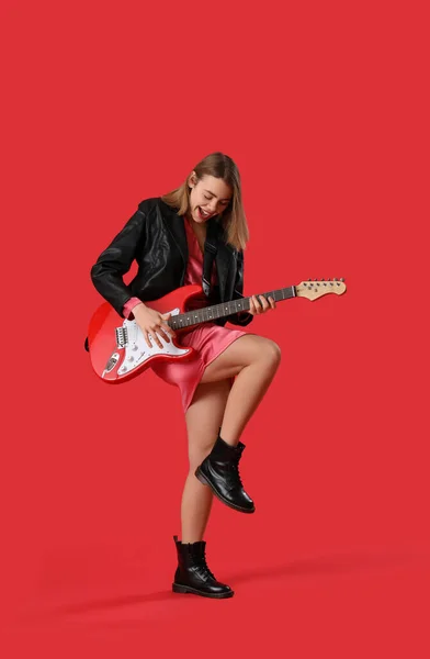 Ung Kvinne Som Spiller Gitar Rød Bakgrunn – stockfoto