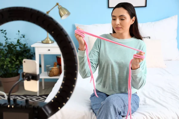 女性博主在卧室的性商店里对绳子进行视频评论 — 图库照片