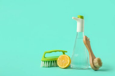 Bir şişe sirke, fırça ve arkaplanda limon.