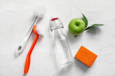 Sirke, sünger, fırça ve elma.