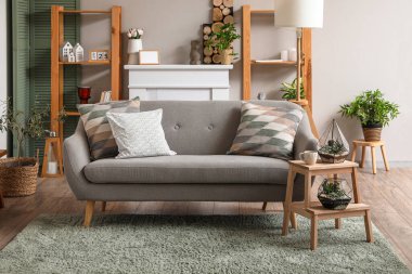 Oturma odasının içinde, merdivende ve kanepede floraryumlar var.