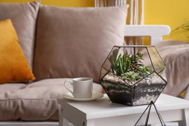 Oturma odasında merdivende kahve fincanı olan Floraryum, yakın plan.