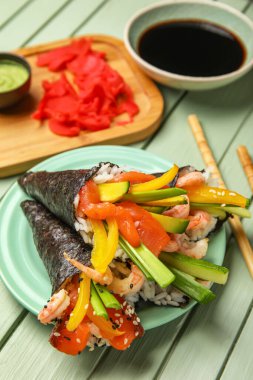 Lezzetli suşi konileri, soya sosu, zencefil ve ahşap arka planda wasabi, yakın plan.