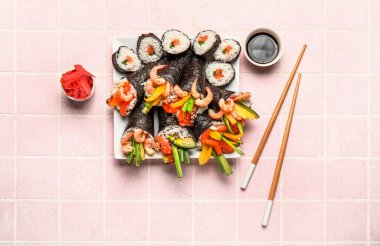 Lezzetli suşi konileri, rulo, zencefil, soya sosu ve rengarenk çubuklarla dolu tabaklar.