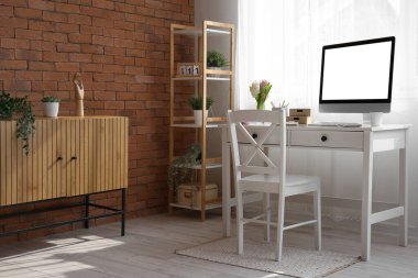 Modern bilgisayar ve pencerenin yanındaki güzel sümbül çiçekleriyle rahat bir iş yeri.