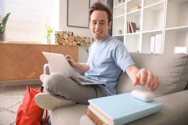 Erkek öğrenci evde ders yaparken müzik dinleyecek.