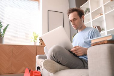 Bilgisayarlı erkek öğrenci evde sınava hazırlanıyor.