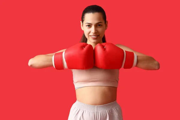 Junge Frau Mit Boxhandschuhen Auf Rotem Hintergrund — Stockfoto