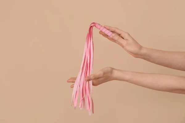 女性とともにピンク鞭からセックスショップ上のベージュの背景 — ストック写真