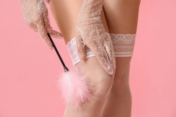 性感女人 带着羽毛棒从粉色背景的性商店出来 特写镜头 — 图库照片