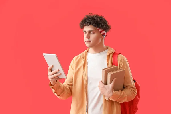 Άνδρας Φοιτητής Tablet Υπολογιστή Και Βιβλία Κόκκινο Φόντο — Φωτογραφία Αρχείου