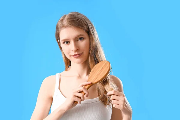 Молода Жінка Проблемою Випадіння Волосся Чистить Синьому Фоні — стокове фото