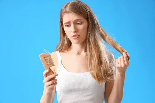 Upset Young Woman Comb Fallen Hair Blue Background — Stock Photo, Image