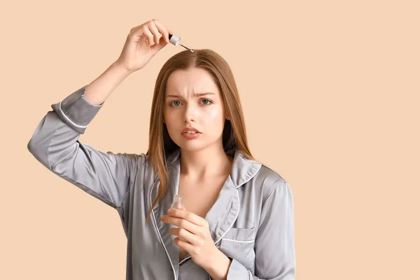 Молода Жінка Використовує Сироватку Лікування Випадіння Волосся Бежевому Фоні — стокове фото