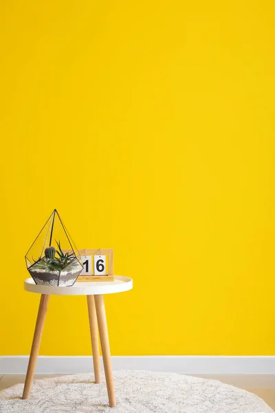 Florário Com Calendário Mesa Perto Parede Amarela Quarto — Fotografia de Stock