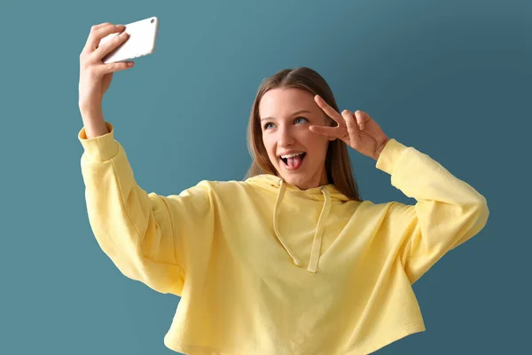 Dospívající Dívka Mobilním Telefonem Selfie Modrém Pozadí — Stock fotografie