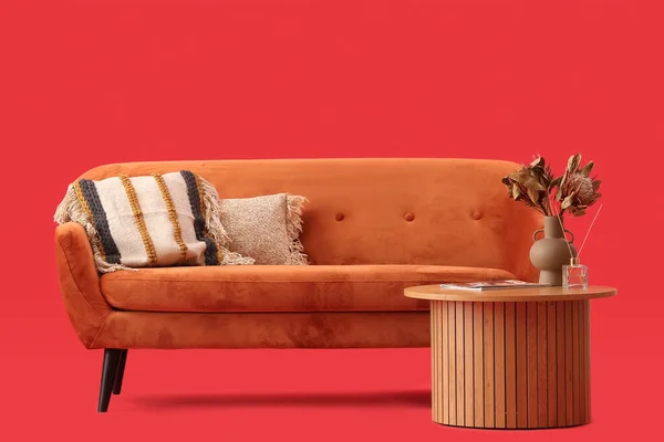 Gemütliches Braunes Sofa Mit Kissen Und Couchtisch Auf Rotem Hintergrund — Stockfoto