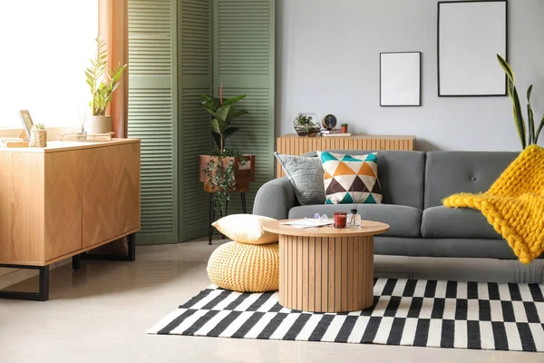居心地の良いグレーのソファとコーヒーテーブルのリードディフューザー付きのスタイリッシュなリビングルームのインテリア — ストック写真
