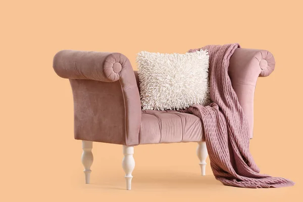 ベージュの背景に毛布とクッションと居心地の良いピンクのソファ — ストック写真