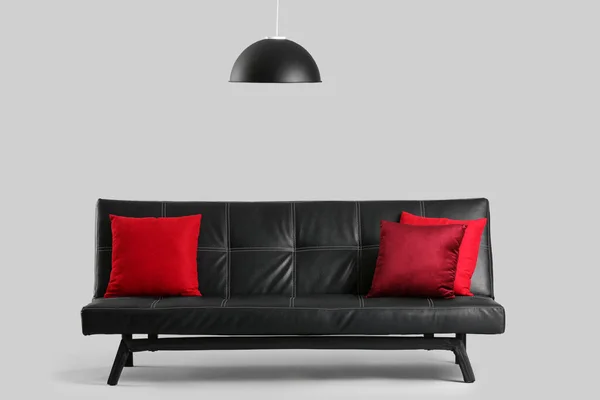 Sofá Elegante Negro Con Cojines Rojos Sobre Fondo Gris —  Fotos de Stock