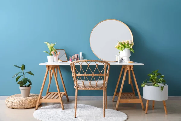 青い壁の近くに異なる化粧品やチューリップの花のテーブル — ストック写真