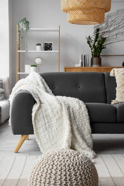 リビングルームで柔らかい毛布と居心地の良いグレーのソファ — ストック写真