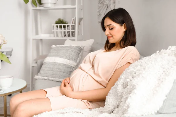 Νεαρή Έγκυος Γυναίκα Κάθεται Στον Καναπέ Στο Σπίτι — Φωτογραφία Αρχείου